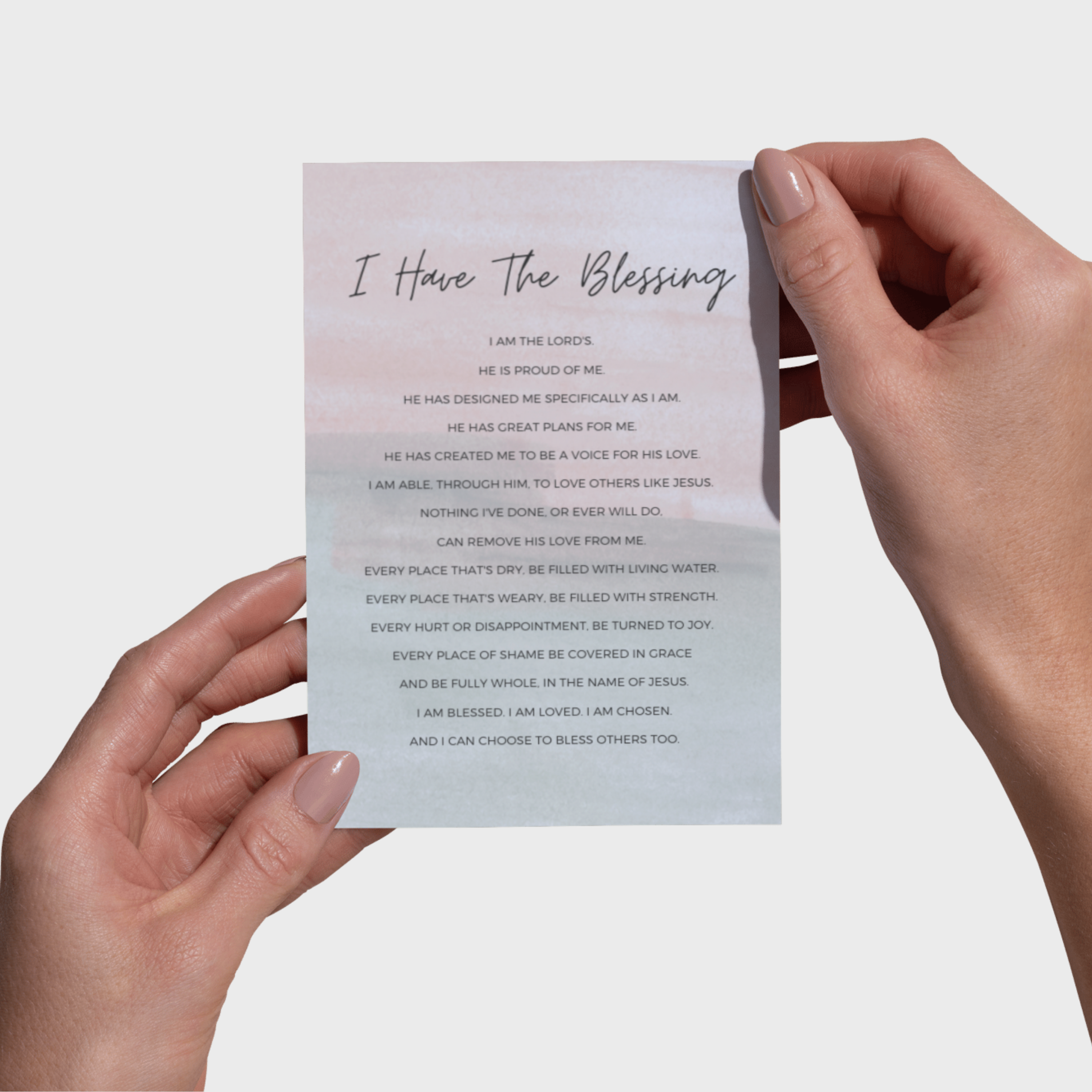 Hands holding a 5x7 print with black text on a light background