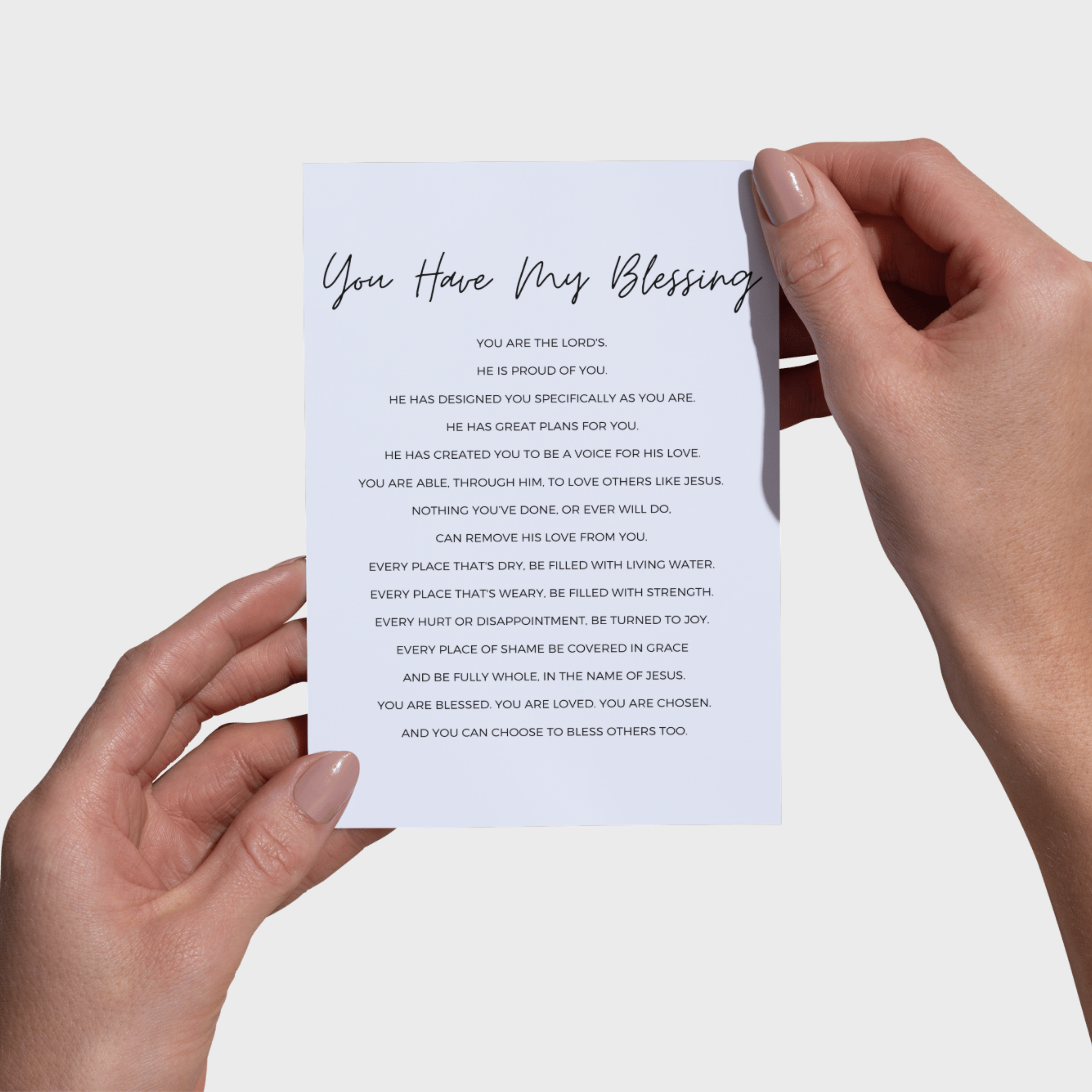 Hands holding a 5x7 print with text 'You Have My Blessing' against a light background