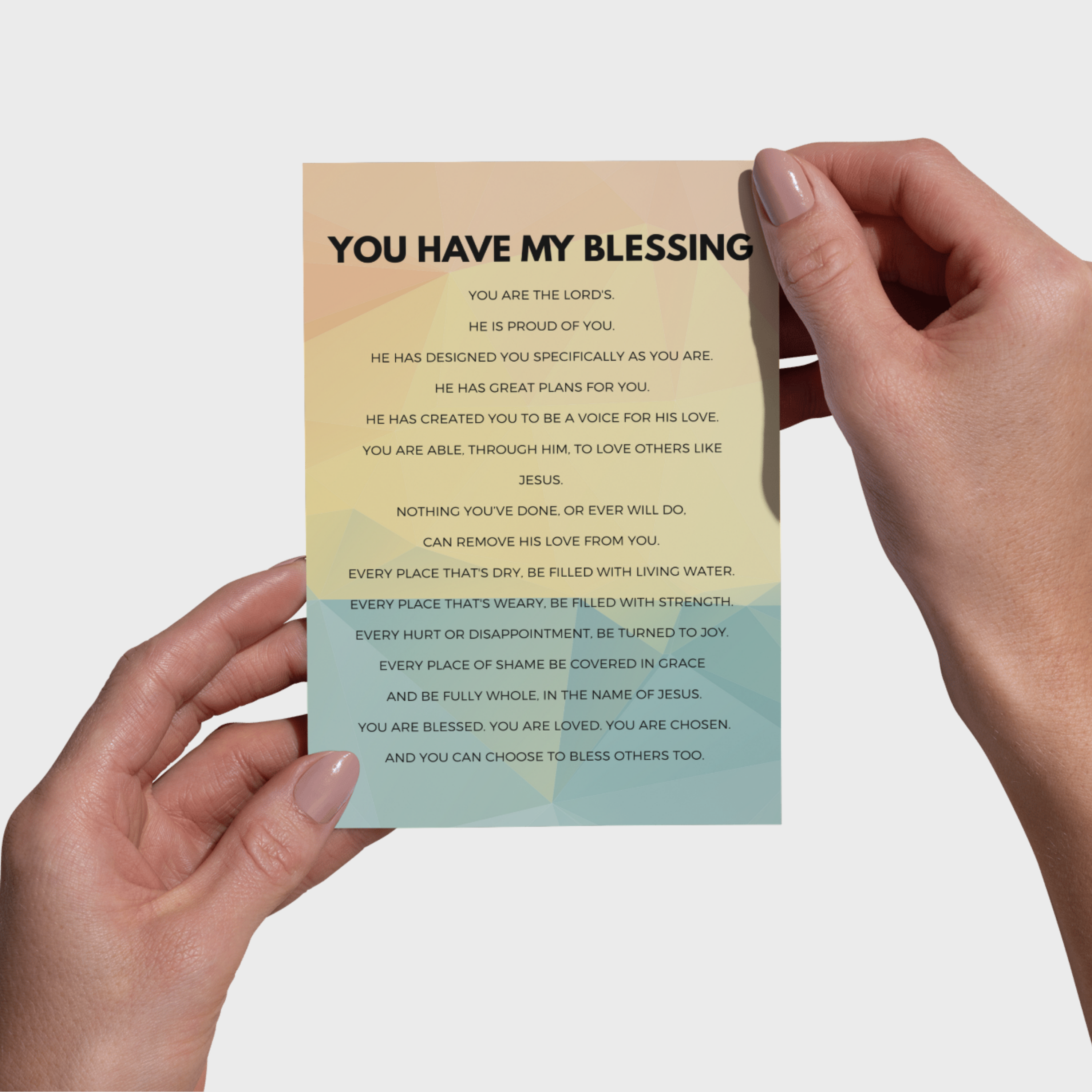 Hands holding a 5x7 print with motivational text on a plain background