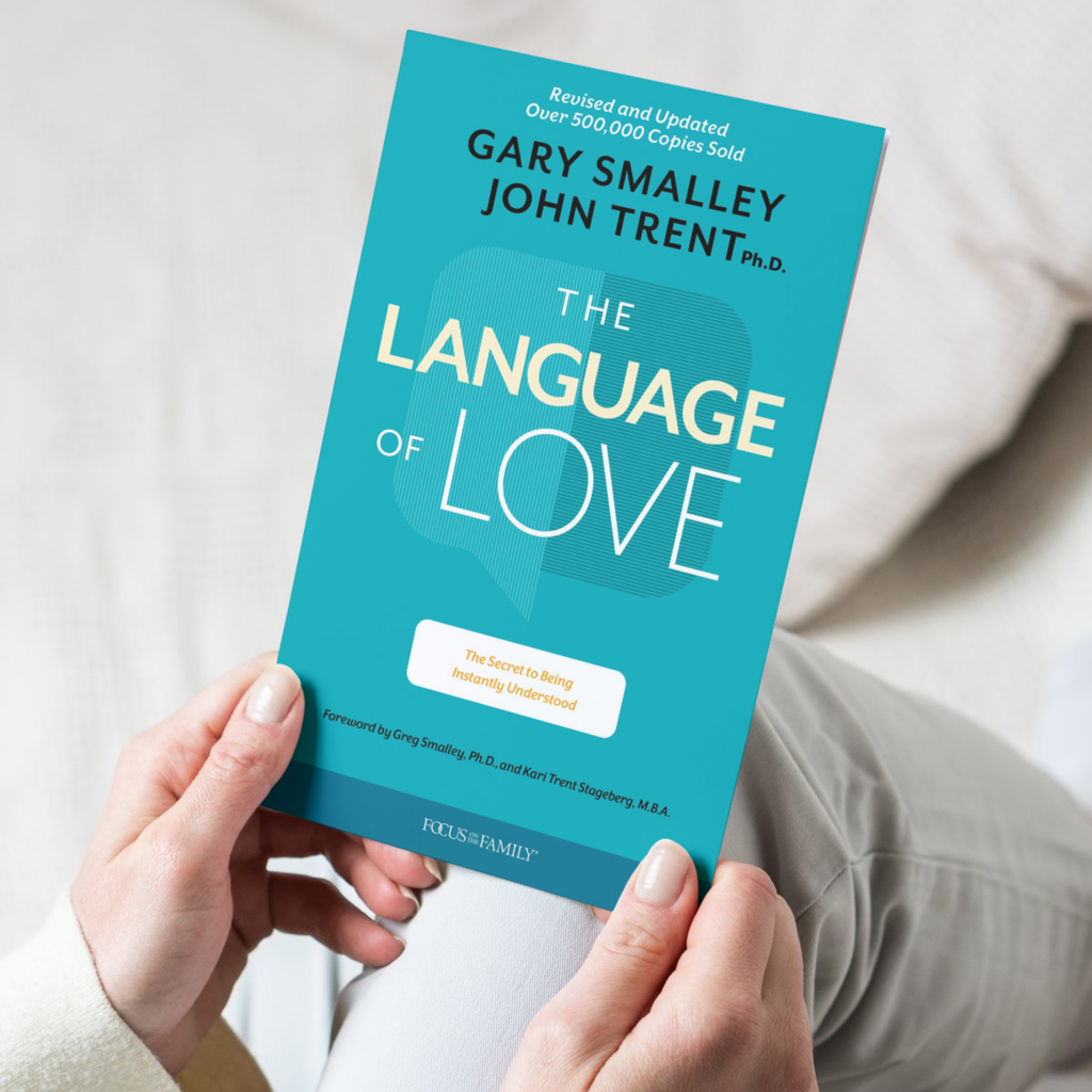 Book titled 'The Language of Love' by Gary Smalley and John Trent held by a person.