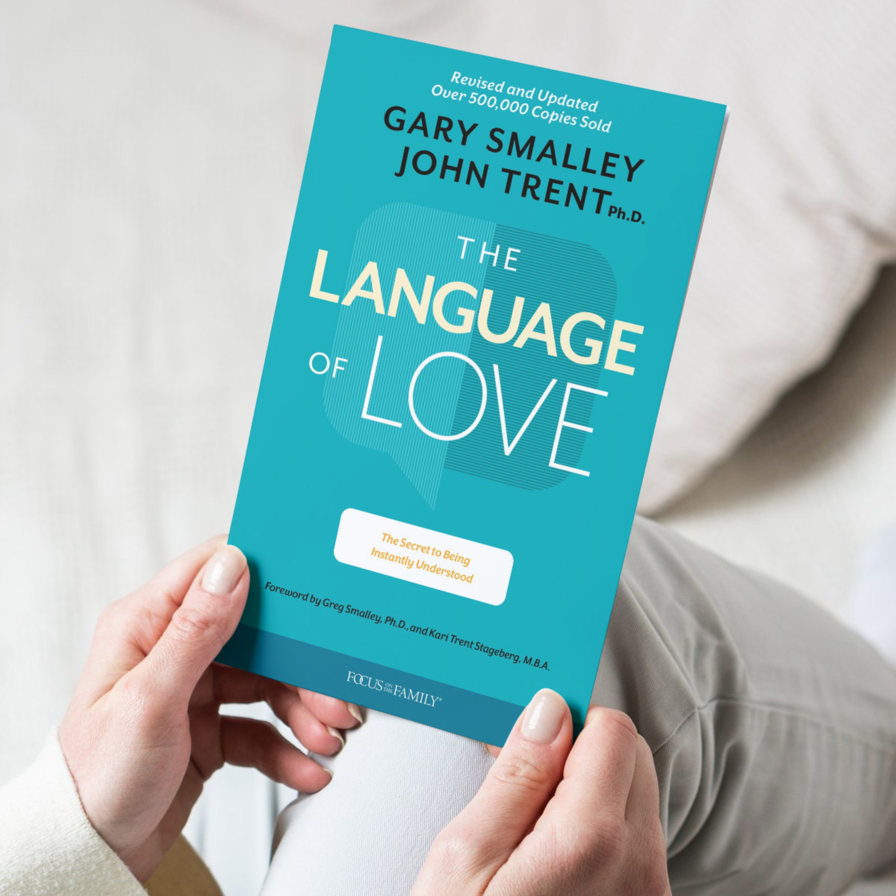 Book titled 'The Language of Love' by Gary Smalley and John Trent held by a person.