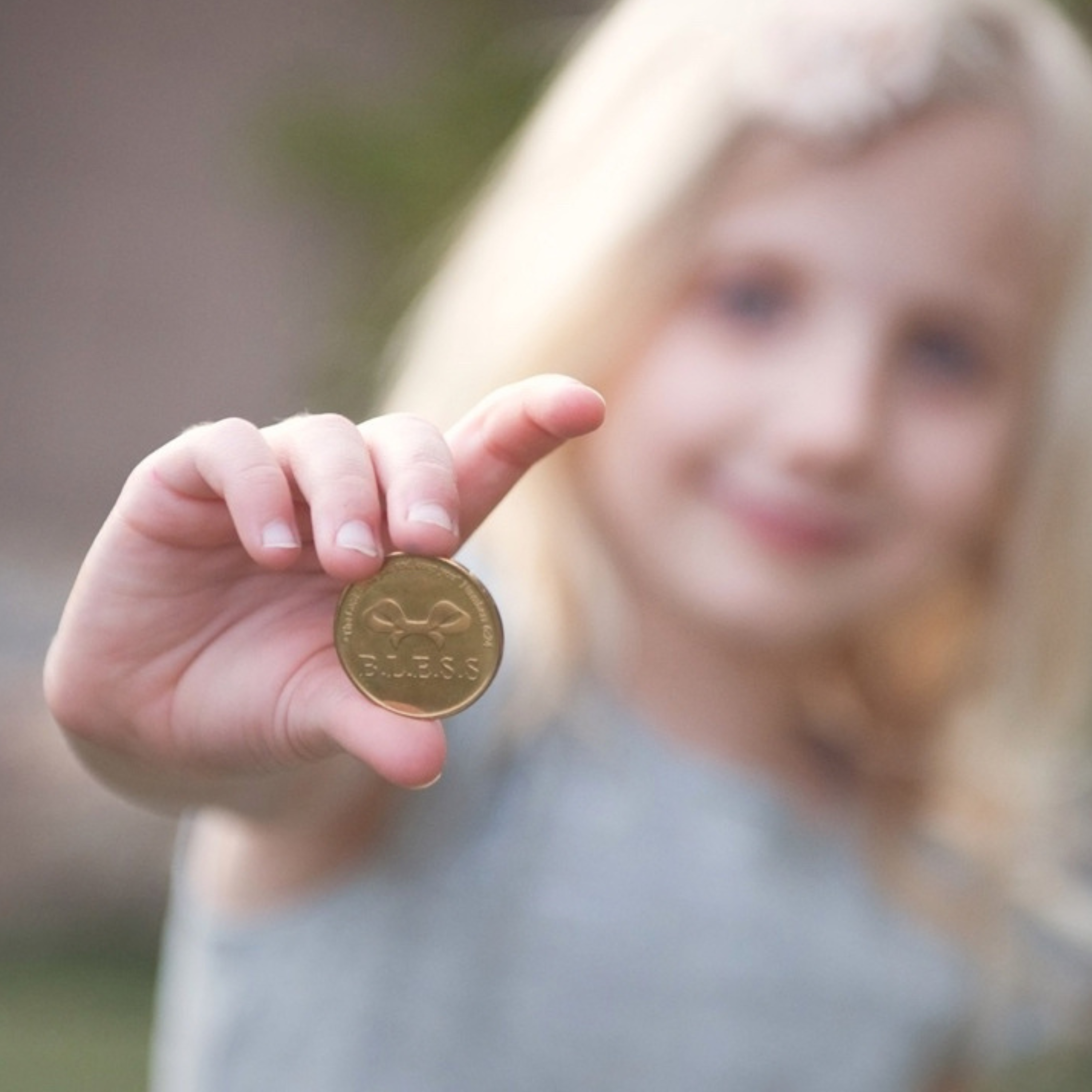 young girl holding a blessing coin